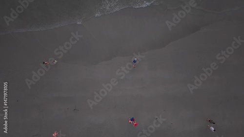 Tourists strolling along sandy coastline during twilight hours on koh chang island, thailand, experiencing peaceful vacation moments against scenic tropical landscape