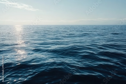 Deep Blue Ocean Surface Reflecting Sunlight With A Clear Horizon Under A Pale Sky On A Bright Day Maritime Scenery