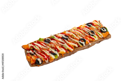A long open-faced sandwich, possibly a Zapiekanka, topped with melted cheese, vegetables, and sauce, presented on a white background.