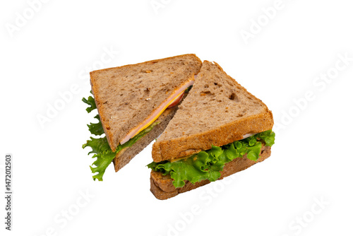 Two ham sandwiches with lettuce, tomato, and ham on whole-wheat bread are isolated on a white background.