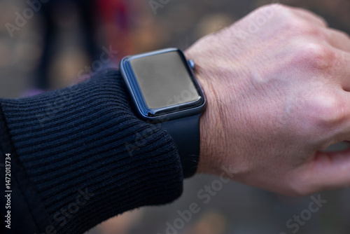 Smart watch with a black monitor on a male hand. Top view