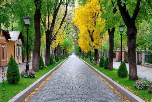 A tree-lined avenue in autumn with colorful leaves covering the sidewalk and street