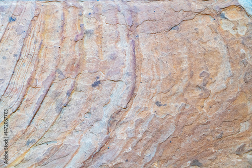 close-up view of layered sandstone with rich brown and orange tones, showcasing organic striations and natural geological patterns.