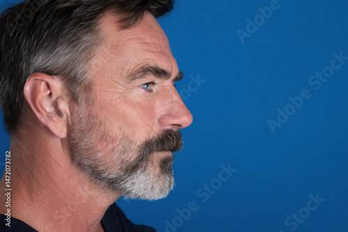 navigator portrait on bright ultramarine background focused expression face positioned on right side of frame