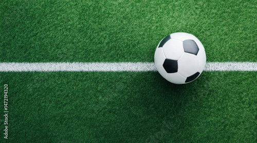 A classic black and white soccer ball rests on a vibrant green artificial turf field, positioned near a crisp white line marking the pitch. : Generative AI