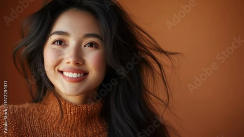 Smiling woman with long hair against orange background  
