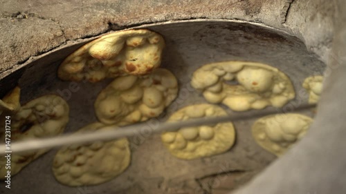 Tandoori roti, naan or flat bread making in tradition clay oven, Mumbai, India