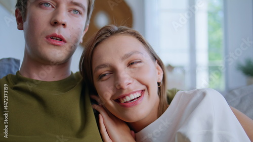 Obraz na płótnie Laughing woman bonding boyfriend watching movie at home closeup. Embracing pair w salonie