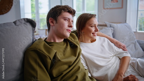 Obraz na płótnie Happy lovers watching tv together on weekend. Teenager couple embracing on sofa w salonie