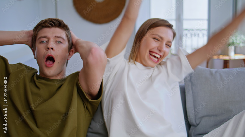Young couple competing online sitting sofa at home closeup. Woman winning game