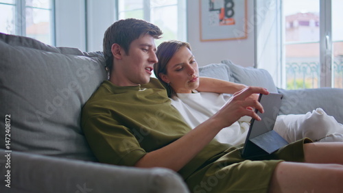 Obraz na płótnie Romantic teenagers watching tablet at weekend. Embracing pair shopping online w salonie