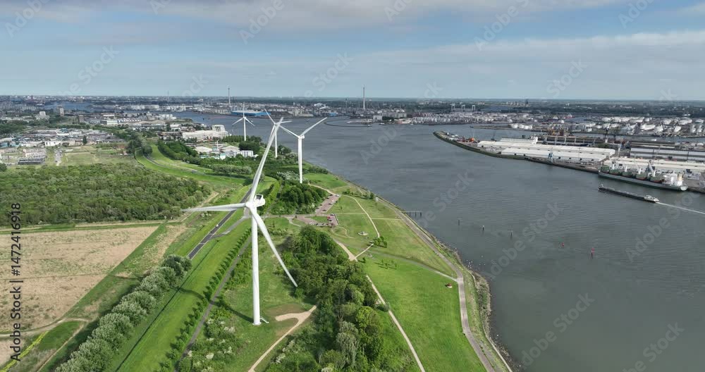 the Maas river surrounded by green fields with wind turbines, industrial zones and buildings
