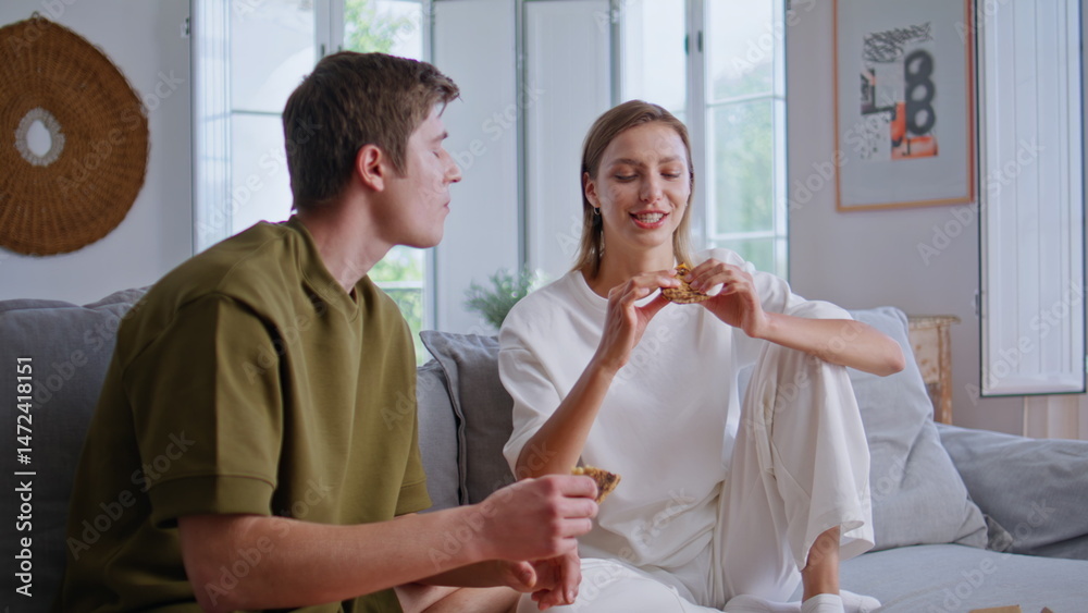 Eating pair watching television together sitting comfortable couch at light flat