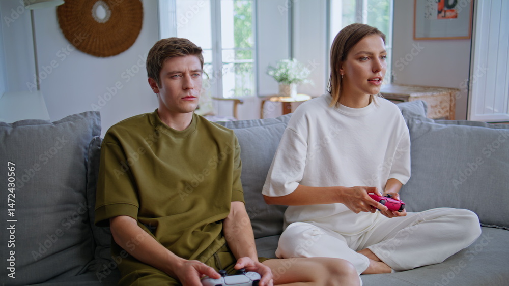 Man woman pressing console buttons playing online video game competition at home