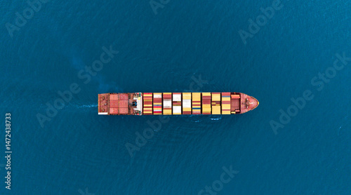 Top view Cargo Container ship with contrail in the ocean ship carrying container and running for import export concept technology freight shipping by ship.
