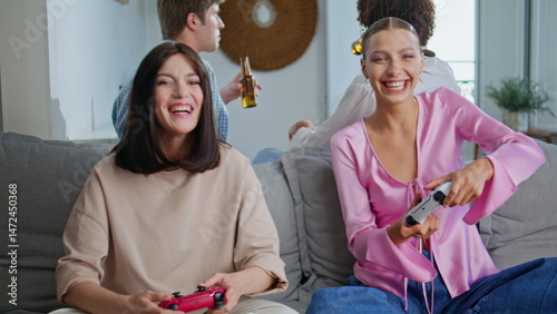 Obraz na płótnie Emotional girls playing together have fun at home meeting closeup. Video gamers w salonie
