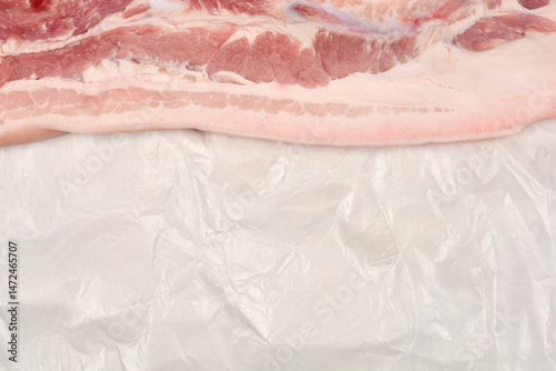 Obraz na płótnie A raw piece of pork belly with distinct layers of meat and fat rests on white butcher paper w salonie