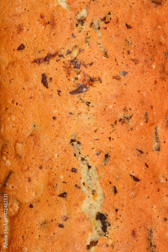 Obraz na płótnie The textured surface of a freshly baked loaf cake with walnuts, raisins, chocolate pieces, and orange zest w salonie