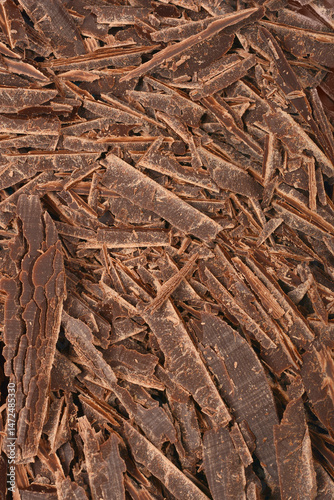 A close-up shows a pile of dark chocolate shavings with a rich, textured surface