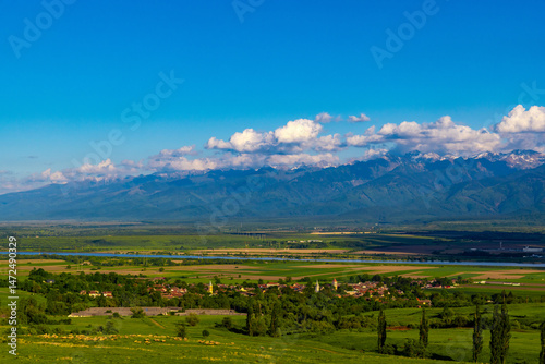 Landscape with a small village in the foreground and the Fagaras Mountains of Romania in the background photo