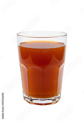 Glass cup containing amber beverage on black backdrop, light on amber liquid, clear glass cup