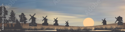 group of obsolete windmills silhouettes at sunset