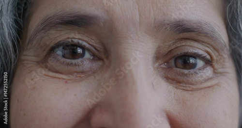 Close-up portrait of senior woman's eyes looking at camera with happy expression. Elderly person and body part concept.