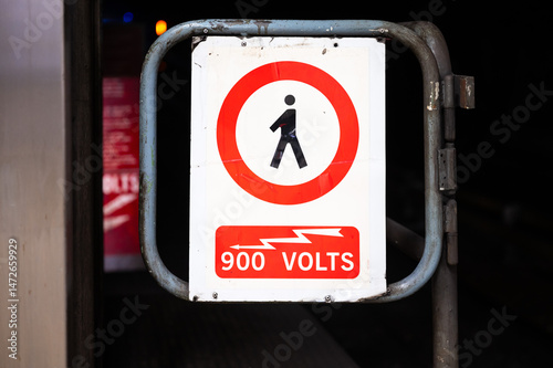 900 Volts danger, no trespassing sign at the railway tracks and tunnel of metro Compte de Flandre, Molenbeek, Belgium