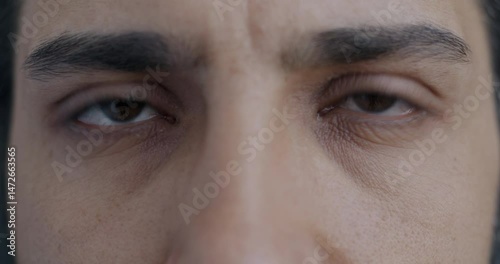 Close-up portrait of Middle Eastern man's eyes looking at camera with tense expression. People and body part concept.