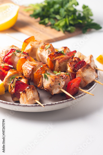 Delicious grilled chicken skewers with capsicum, lemon, salad and ketchup on a plate over the table. Chicken kebab. Healthy food concept.