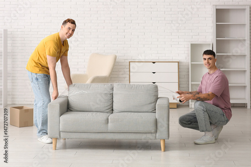 Two young men wrapping sofa...