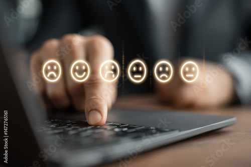 Finger selecting digital emoji face on laptop keyboard representing customer feedback and satisfaction rating
