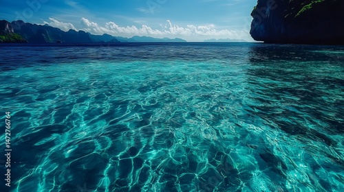 Fototapeta Naklejka Na Ścianę i Meble -  Stunning turquoise ocean water with mountain view background sea sky sun blue calm green clear beach