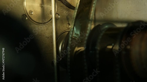  Macro shot: Vintage film strips glide through intricate projector or scanner rollers. Evokes cinema nostalgia and analog processes. Perfect for archival, retro, or filmmaking themes.