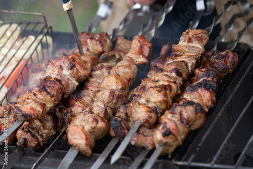 Freshly cooked and fried pork shashlik strung on skewers lies on the grill and is ready for a treat.