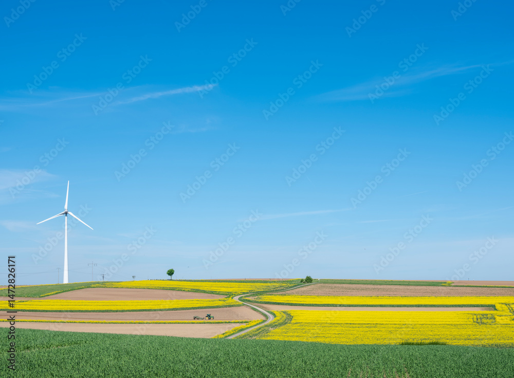 countryside landscape in luxemburg with wind turbine under blue sky in spring