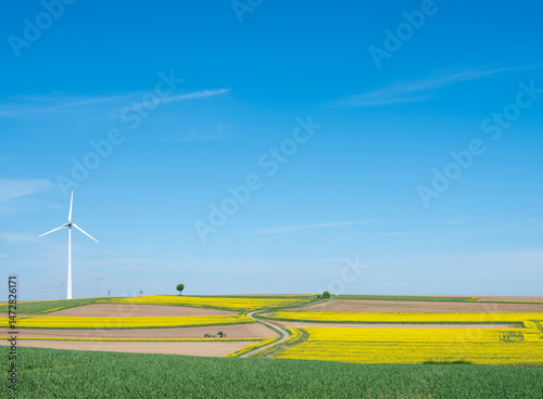 Obraz na płótnie countryside landscape in luxemburg with wind turbine under blue sky in spring w salonie