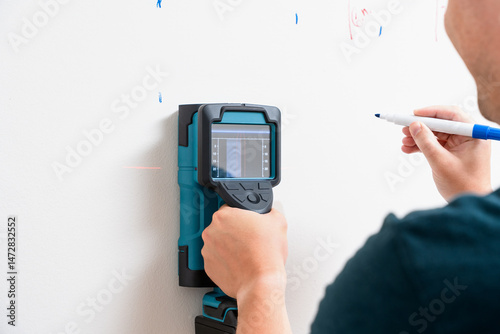 Worker Using Wall Scanner and Marking Stud Location photo