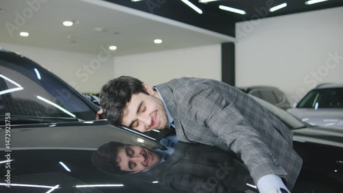 Bright modern car showroom features a happy young man embracing a vehicle, showcasing excitement and connection to the new car