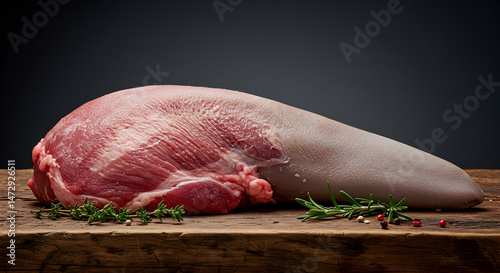 Fresh Raw Beef Tongue With Herbs Displayed on Rustic Wooden Surface