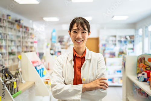 Smile japanese pharmacist is posing in a pharmacy shop Free Download Smile japanese pharmacist is posing in a pharmacy shop - GFXLoad
