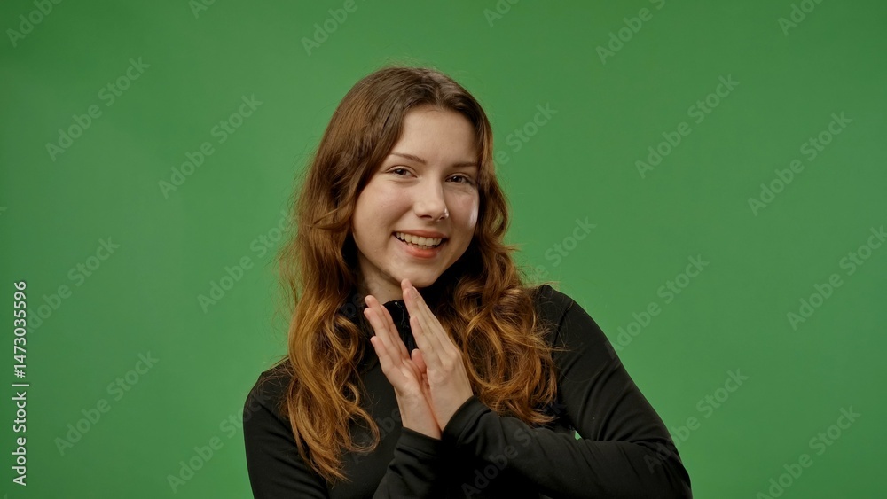 Teenage girl posing at camera and clapping, smiling positive expression, isolated on chroma key green screen studio background mockup. Teenage girl posing at camera and clapping, smiling positive expression, isolated on chroma key green screen studio background mockup.