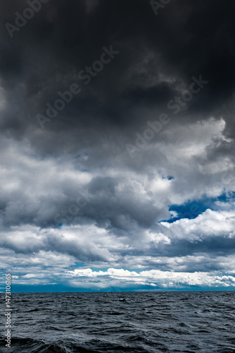 The dark sky with heavy clouds converging and a violent storm before the rain.Bad or moody weather sky and environment. carbon dioxide emissions, greenhouse effect, global warming, climate change.