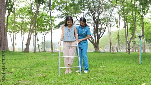 Elderly woman holding a cane being cared for by a female nurse in the park, natural therapy concept, employee or caregiver for the elderly