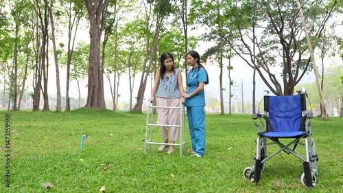 Elderly woman holding a cane being cared for by a female nurse in the park, natural therapy concept, employee or caregiver for the elderly