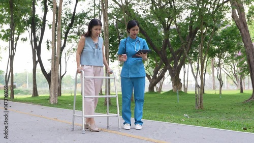 Elderly woman holding a cane being cared for by a female nurse in the park, natural therapy concept, employee or caregiver for the elderly