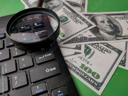 Closeup magnifying glasd,banknote and keyboard business online concept