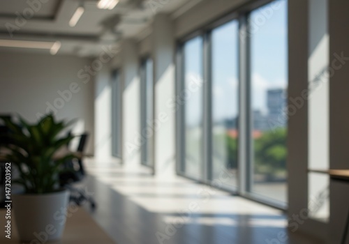 Blurred office interior with potted plant and large windows showing city view
