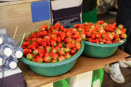 Fresh red strawberries in bowls for sale at a market in Shanghai, China. Juicy and sweet, perfect for small business and retail photo