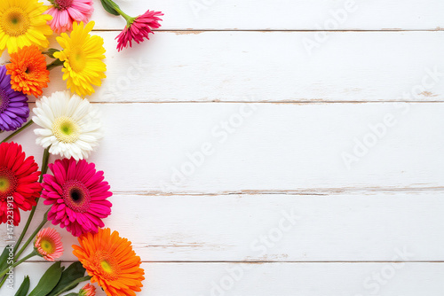 bunch of colorful gerbera daisies on a white wooden background